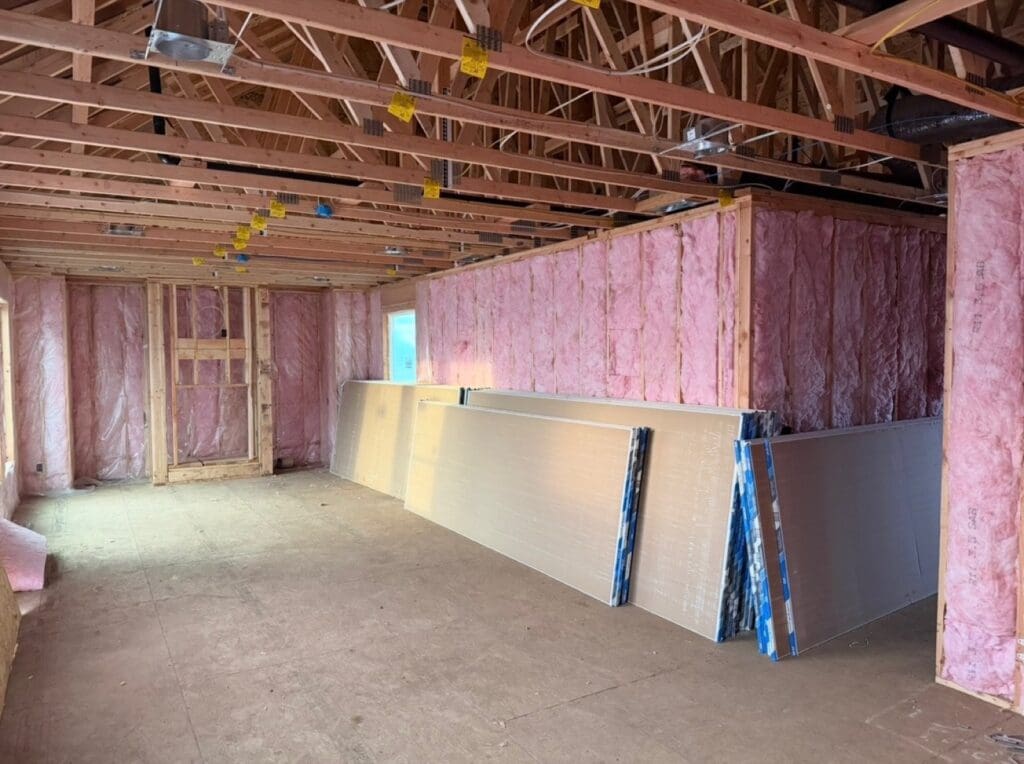 New-build walls filled with pink fiberglass batts