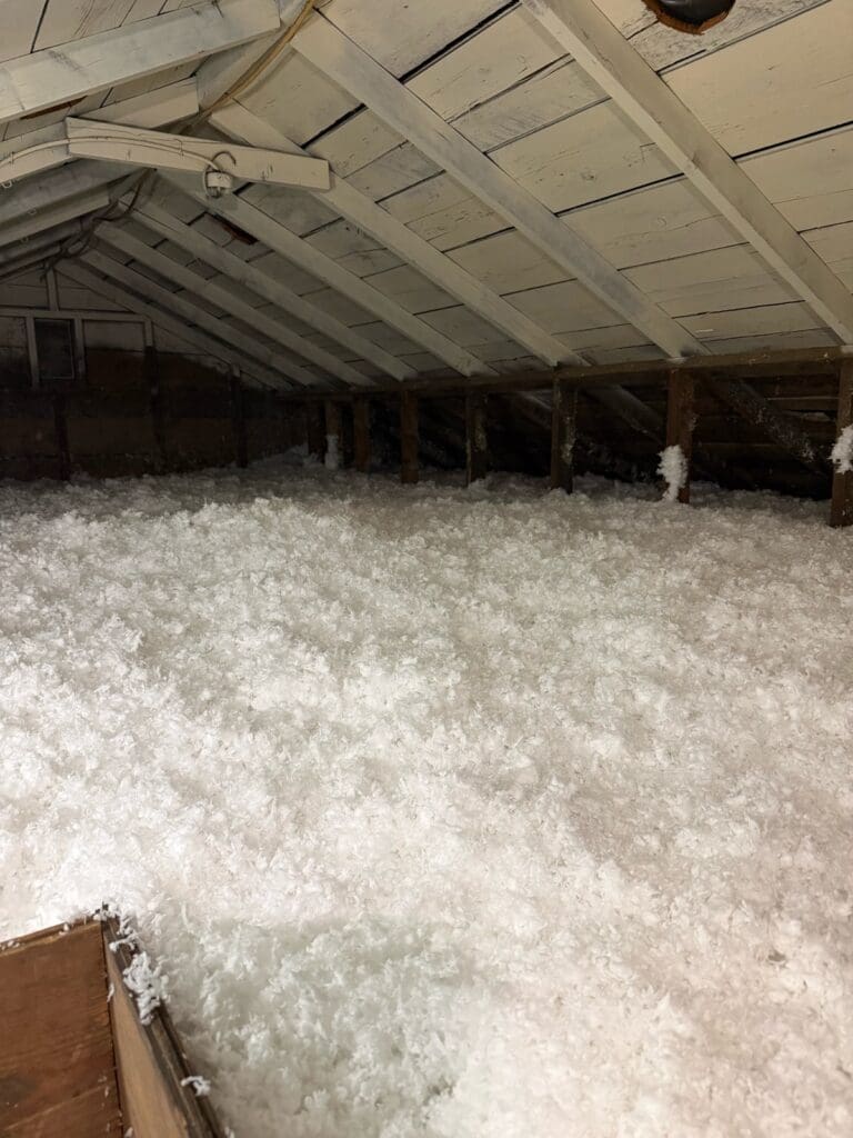 Attic with new blown fiberglass insulation after the old insulation was removed